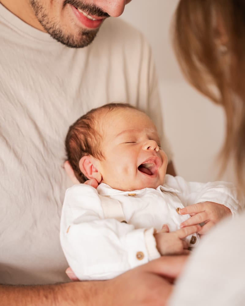 Portrait tendre d'un nouveau-né dans les bras de ses parents